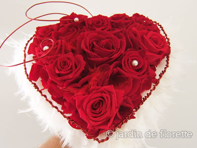 Bouquet de mariée en forme de coeur à base de roses rouges éternelles et de plumes blanches