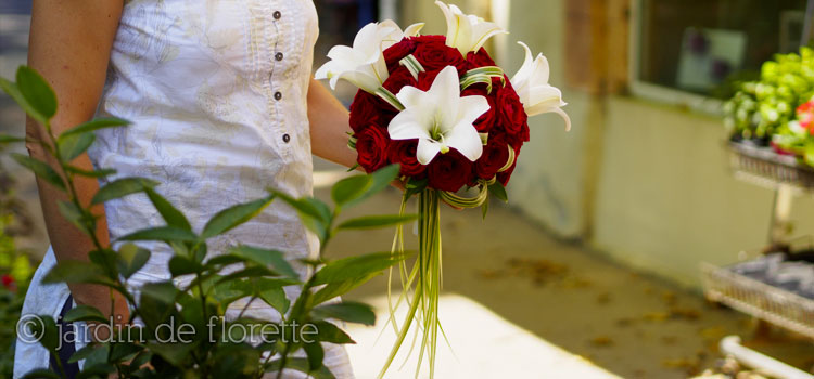 Bouquet de mariée rond à base de roses rouges et de lys blancs